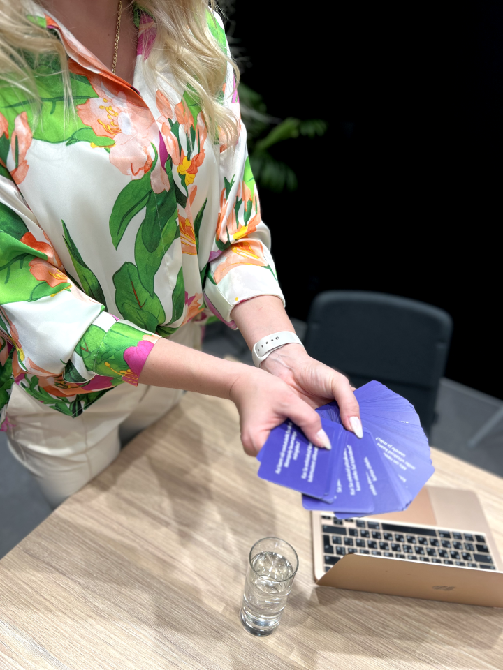 Игровые карточки в женских руках на фоне рабочего стола с ноутбуком